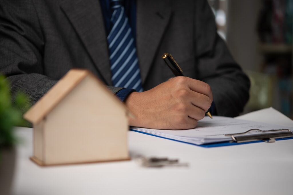 Businessman signing contract for buying a house or real estate agent. Investment and bank loan